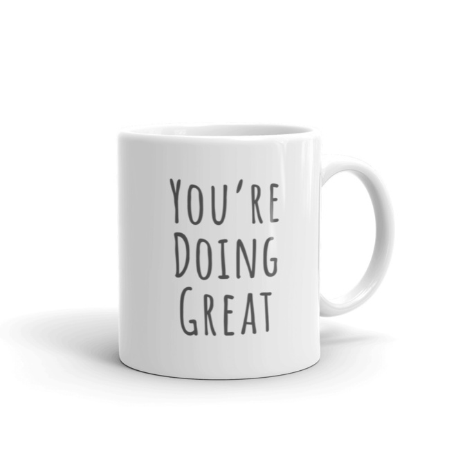 White mug that says "You're Doing Great"