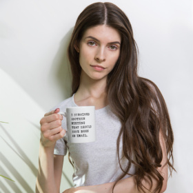 Woman holding white mug that says I SURVIVED ANOTHER MEETING THAT SHOULD HAVE BEEN AN EMAIL. 11oz